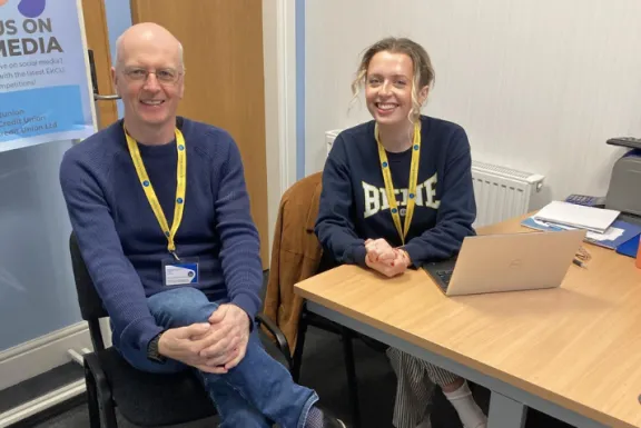 2 advisers smiling sitting down